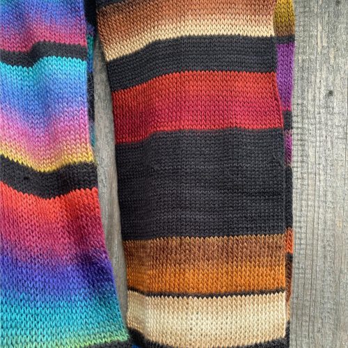 Striped scarf knitted from black wool with accent color bands