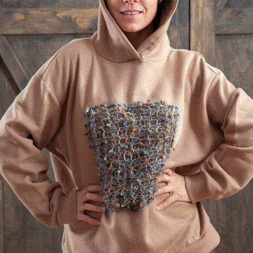 Sand color sweater with decor and hood.